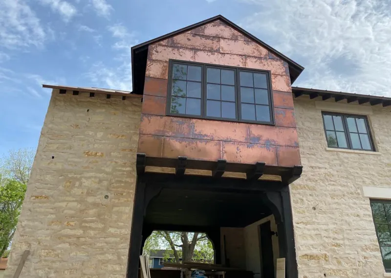Copper metal panel facade on a stone building for Skylight Installation in Stephenville